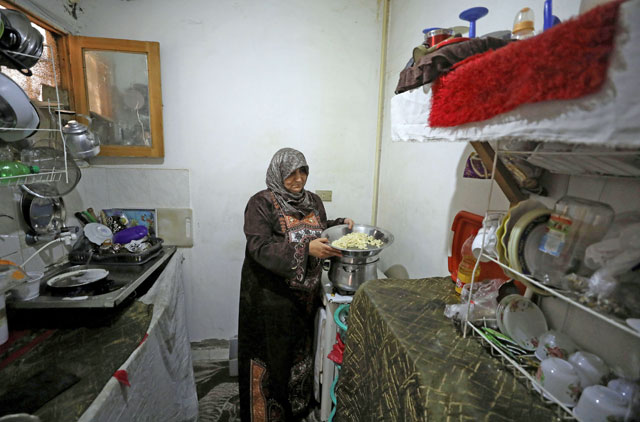 Syrian refugee Ilham Mohammad prepares lunch in her home in Cairo, Egypt, on Monday (Reuters photo)